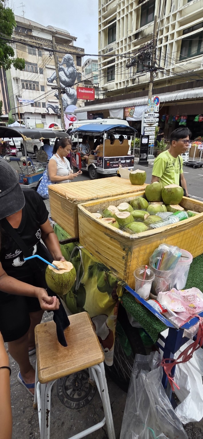 Street vendor opening fresh coconuts in Bangkok