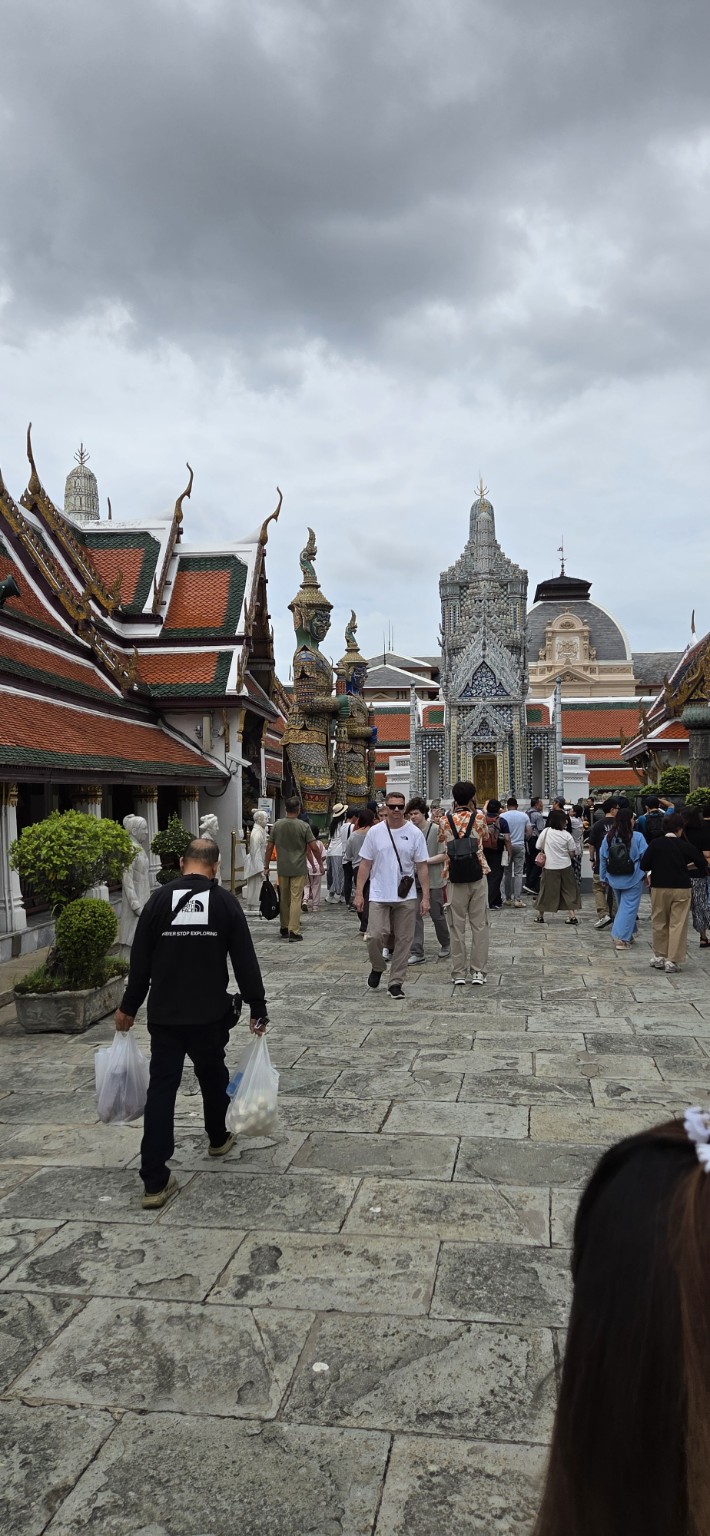 Visitors walking toward a decorated gate in the Grand Palace complex