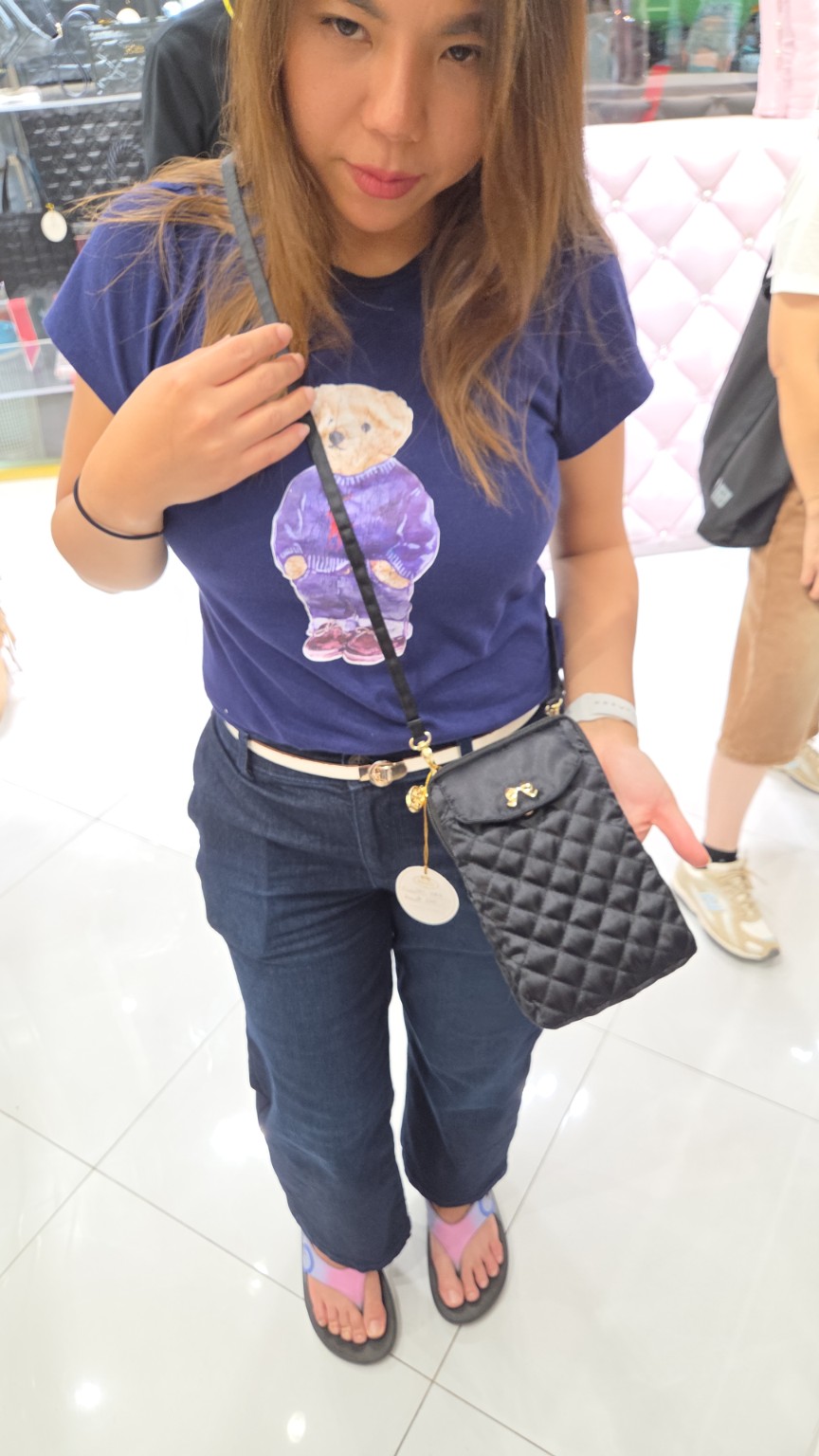 Tana holding a quilted black bag while shopping in Bangkok